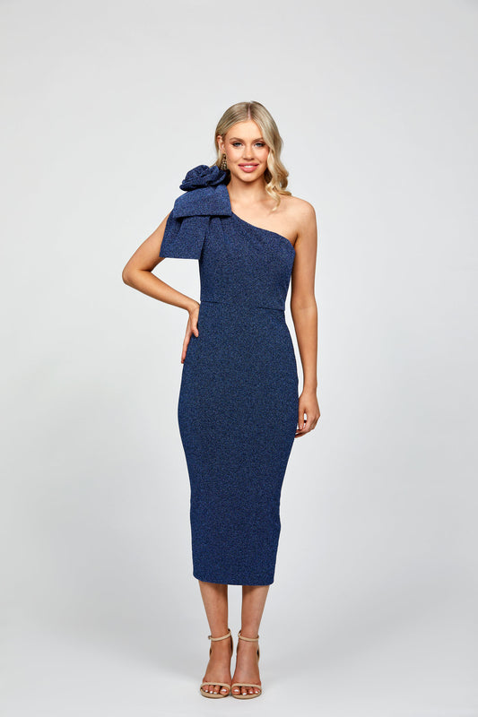 A woman wearing a navy, one-shoulder midi dress with a bow detail on the shoulder, suitable for cocktail or evening events.